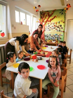Copii și educatoare la masa de Ziua Recunoștinței