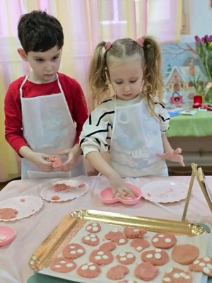 Copii gătind biscuiți cu șorțuri