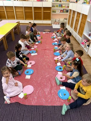 Copii la picnic interior cu farfurii colorate