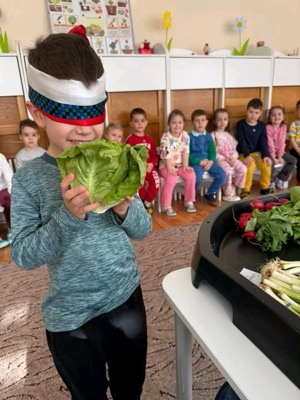 Copil cu ochii legați recunoscând legume