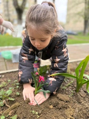 Copil plantând flori în grădină