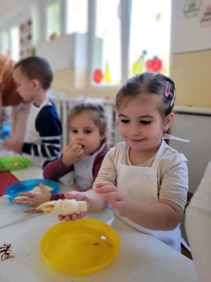 Fetiță modelând cornulețe din aluat